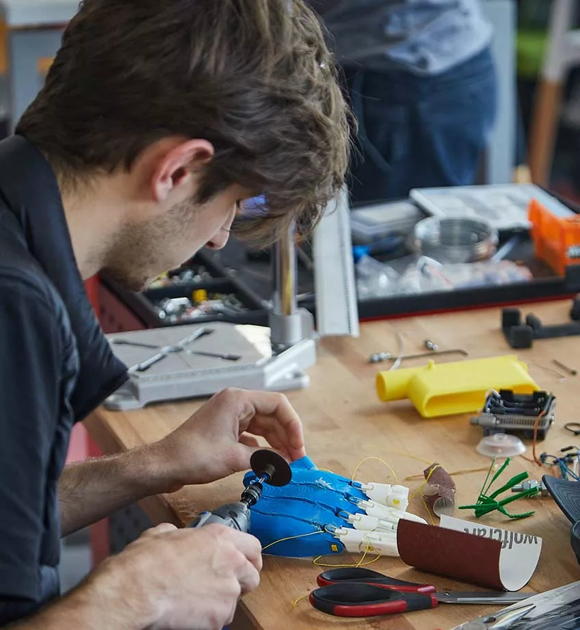 Un étudiant travaillant sur une main robotique