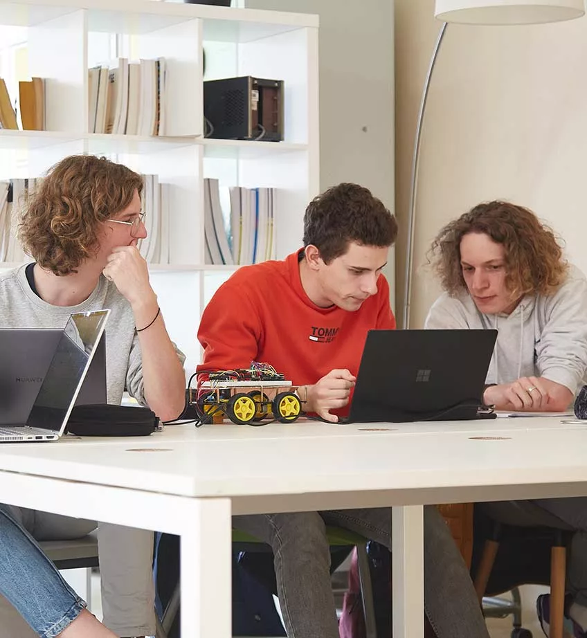 Trois étudiants travaillent sur un projet de véhicule autonome